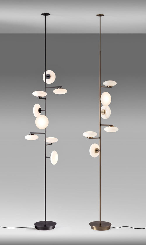 Arya Floor-to-Ceiling Lamp featuring illuminated opal glass discs arranged along a slender architectural frame in black and gold finishes, designed for luxury contemporary interiors