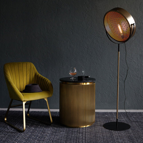 Gold industrial floor lamp with perforated spotlight shade and modern metal stand in a contemporary interior.