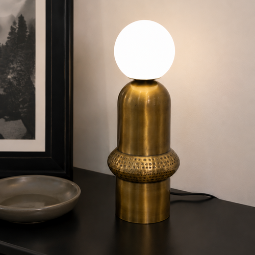 Aureon Table Lamp featuring a brushed brass sculptural base with handcrafted textured detailing and a frosted glass globe, designed for modern luxury interiors.