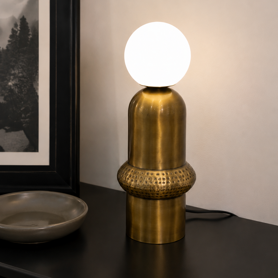 Aureon Table Lamp featuring a brushed brass sculptural base with handcrafted textured detailing and a frosted glass globe, designed for modern luxury interiors.