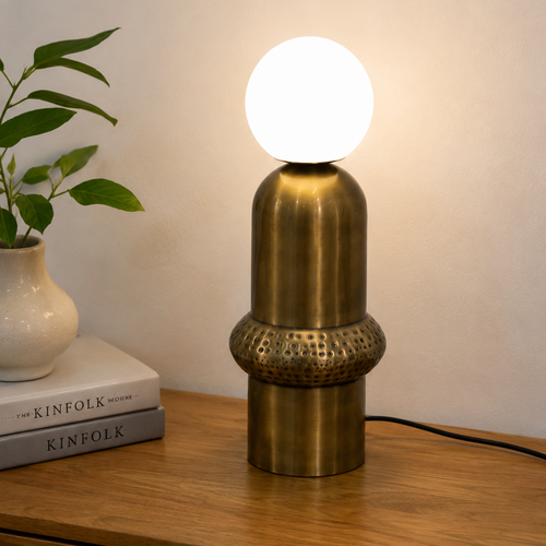 Aureon Table Lamp featuring a brushed brass sculptural base with handcrafted textured detailing and a frosted glass globe, designed for modern luxury interiors.