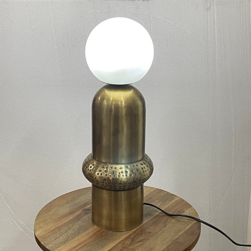 Aureon Table Lamp featuring a brushed brass sculptural base with handcrafted textured detailing and a frosted glass globe, designed for modern luxury interiors.