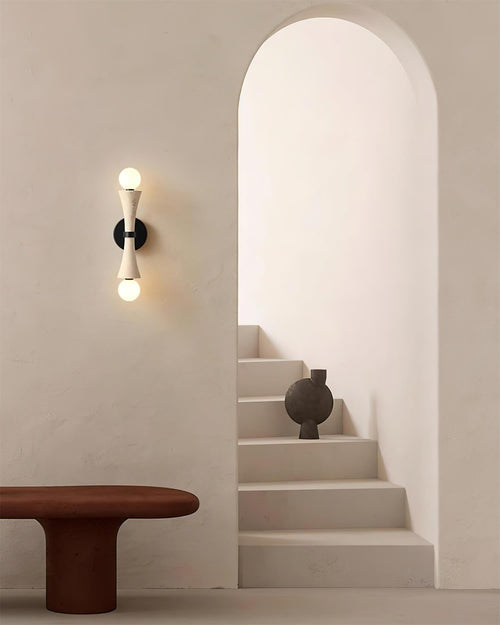 Hecker Travertine Wall Lamp featuring a sculptural natural stone body with dual globe lights and matte black hardware, designed for luxury contemporary interiors.