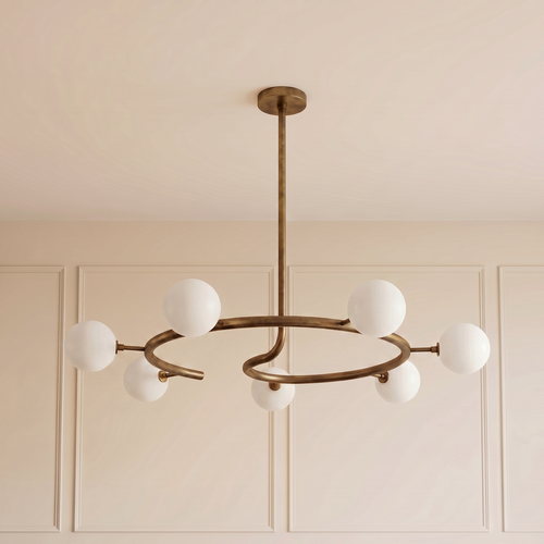 Helix Halo Chandelier with a sculptural brushed brass circular frame and seven matte milk glass globes, creating elegant ambient lighting for contemporary luxury interiors