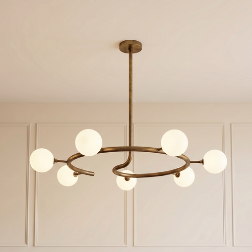 Helix Halo Chandelier with a sculptural brushed brass circular frame and seven matte milk glass globes, creating elegant ambient lighting for contemporary luxury interiors