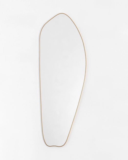 Irregular gold full length mirror mounted on wall in modern interior