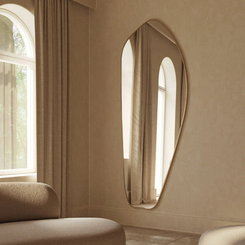 Irregular gold full length mirror mounted on wall in modern interior