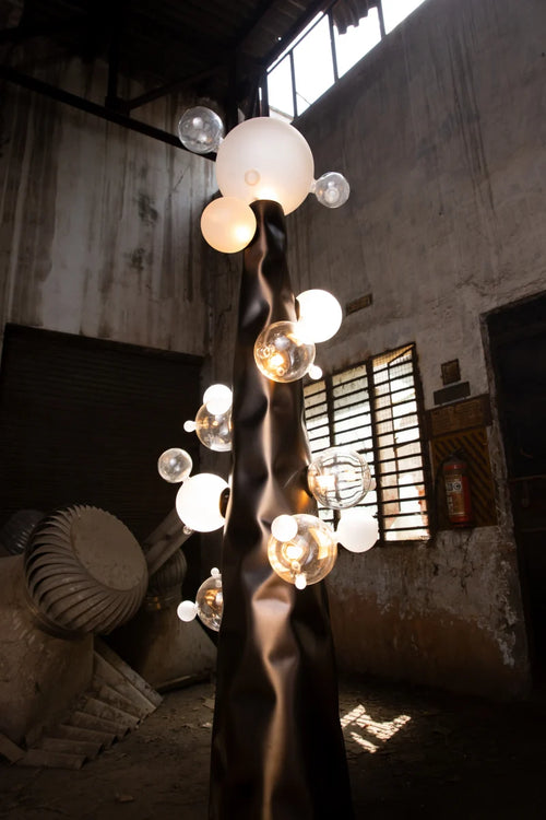 Molecule Floor Lamp featuring hand-blown glass spheres arranged around a sculptural matte gunmetal column, a luxury statement lighting piece for contemporary interiors.