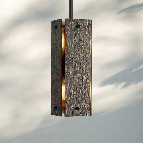 Monolith Pendant featuring a sculptural textured body with metallic detailing, a luxury Brutalist hanging light for modern interiors.