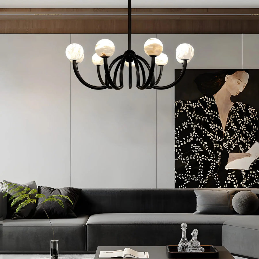 Modern living room with a chandelier, sofa, and wall art.